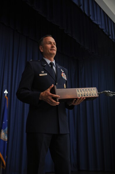 U.S. Air Force Col. Billy Thompson, 23d Wing commander, awards the spirit award during a NCO promotion ceremony at Moody Air Force Base, Ga., Aug. 30, 2012. The 23d Operations Support Squadron won the award for showing the most spirit in supporting the new promotees throughout the ceremony. (U.S. Air Force photo by Airman 1st Class Olivia Dominique/Released)