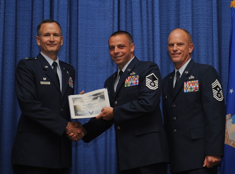 U.S. Air Force Col. Billy Thompson, 23d Wing commander, presents Master Sgt. Mark Carlson, 74th Aircraft Maintenance Unit NCO in charge of support section, a certificate during a NCO promotion ceremony at Moody Air Force Base, Ga., Aug. 30, 2012. Carlson was one of 26 Airmen who were promoted between the ranks of staff sergeant through master sergeant. (U.S. Air Force photo by Airman 1st Class Olivia Dominique/Released)
