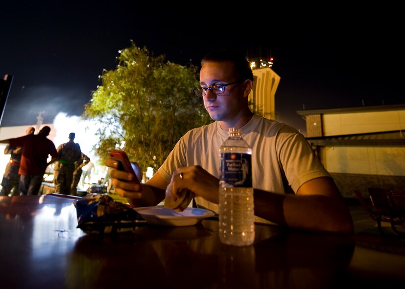 U.S. Air Force Airman 1st Class Keith Henry Jr., 317th Aircraft Maintenance Squadron, enjoys a hamburger during a midnight barbecue Aug. 29, 2012, at Dyess Air Force Base, Texas. The barbeque was held by the Dyess first sergeant’s group and chaplain team for Dyess personnel working swings and mid-shifts.  (U.S. Air Force photo by Airman 1st Class Damon Kasberg/Released)