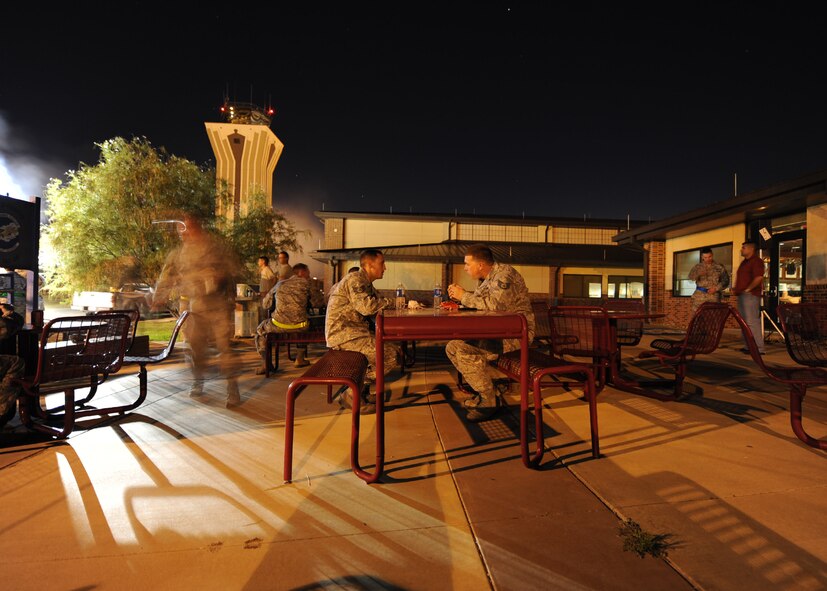 U.S. Air Force Staff Sgt. Antonio Rosa, left, and Staff Sgt. Ryan Bone, 317th Aircraft Maintenance Squadron, enjoy a meal during a midnight barbecue Aug. 29, 2012, at Dyess Air Force Base, Texas. The barbeque was held by the Dyess first sergeant’s group and chaplain team for Dyess personnel working swings and mid-shifts.  (U.S. Air Force photo by Airman 1st Class Damon Kasberg/Released)
