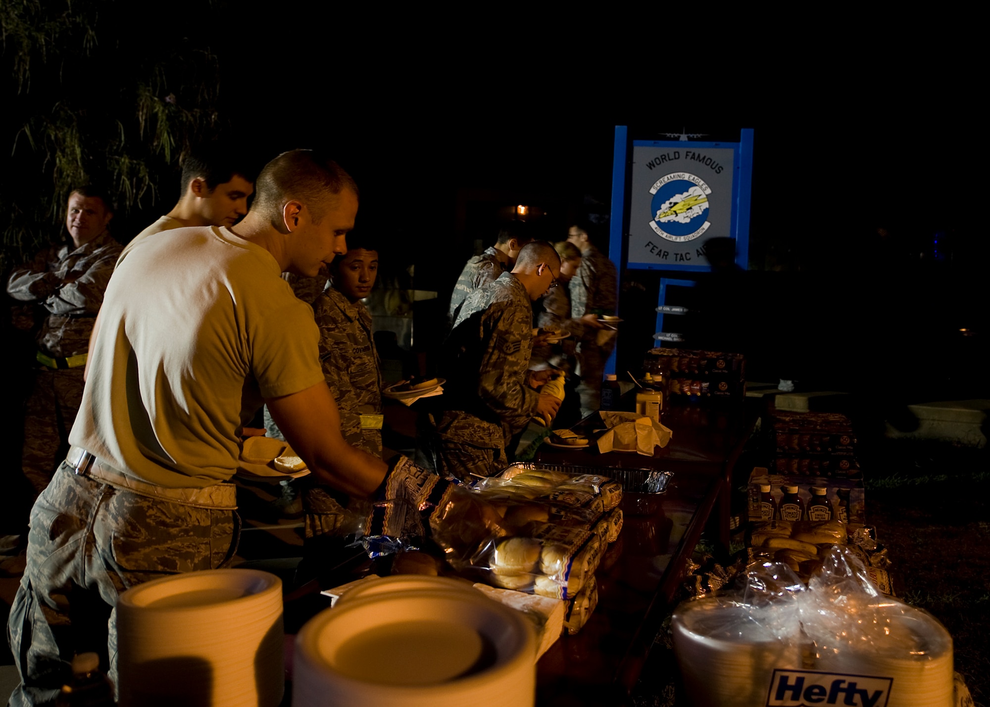 Dyess servicemembers help themselves to hamburgers and hotdogs during a midnight barbeque Aug. 29, 2012, at Dyess Air Force Base, Texas. The barbecue was held by the Dyess first sergeant’s group and chaplain team for Dyess personnel working swings and mid-shifts.  (U.S. Air Force photo by Airman 1st Class Damon Kasberg/Released)