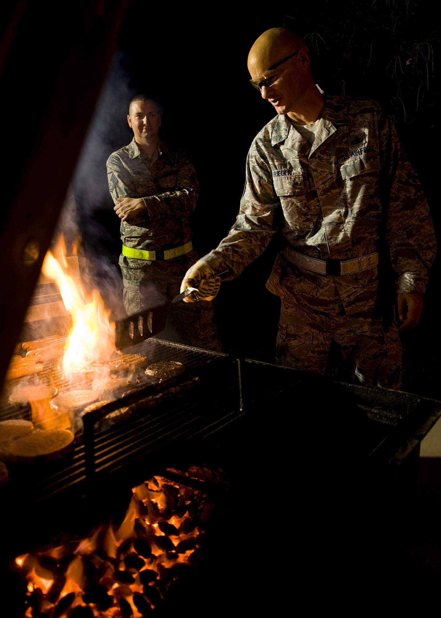 U.S. Air Force Master Sgt. Christopher Krieger, 7th Medical Group first sergeant, prepares burgers for Airmen during a midnight barbecue Aug. 29, 2012, at Dyess Air Force Base, Texas. The barbeque was held by the Dyess first sergeant’s group and chaplain team for Dyess personnel working swings and mid-shifts.  (U.S. Air Force photo by Airman 1st Class Damon Kasberg/Released)