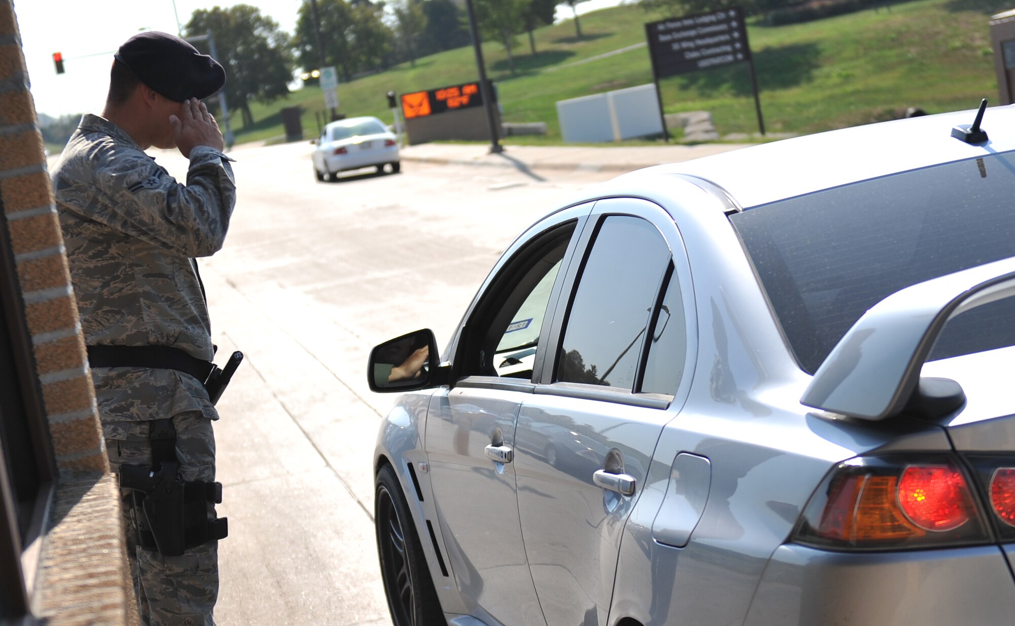 U.S. Air Force Airman 1st Class Timothy Poremba, 55th Security Forces Squadron, salutes an officer entering at the Kenny Gate on Offutt Air Force Base, Neb., Aug. 30. Common courtesies such as the salute are an important part to a good first impression of Offutt AFB. (U.S. Air Force photo by Jeff W. Gates/Released)