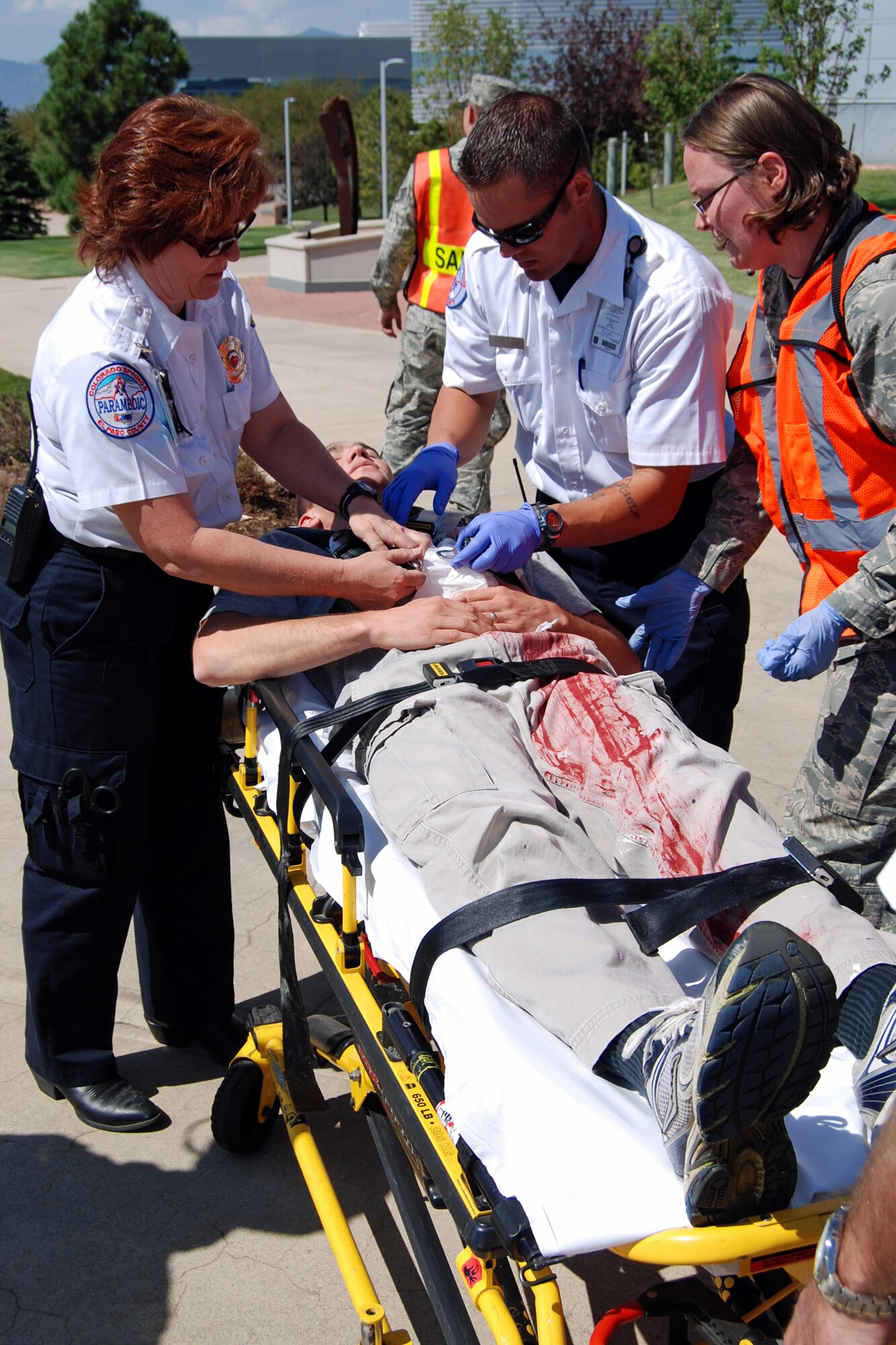 First responders treat the wounds of a shooting victim during an active shooter exercise scenario Aug. 28 near Building 2. The Condor Crest emergency response exercise was held Aug. 26-30 as part of the 21st Space Wing's continued commitment to ensure base readiness. (U.S. Air Force photo/Lea Johnson)