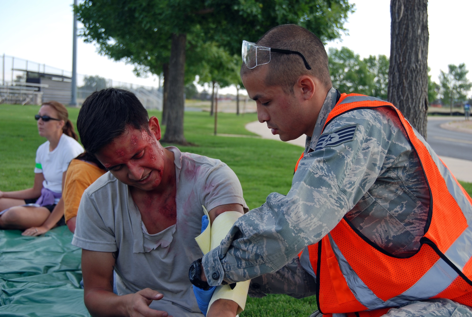 A first responder treats burns on a victim of a lighting strike during a base-wide exercise Aug. 29. During the lightning strike scenario there were multiple injuries that tested the base’s ability to respond to a large scale emergency. The Condor Crest emergency response exercise was held Aug. 26-30 as part of the 21st Space Wing's continued commitment to ensure base readiness. (U.S. Air Force photo/Lea Johnson)