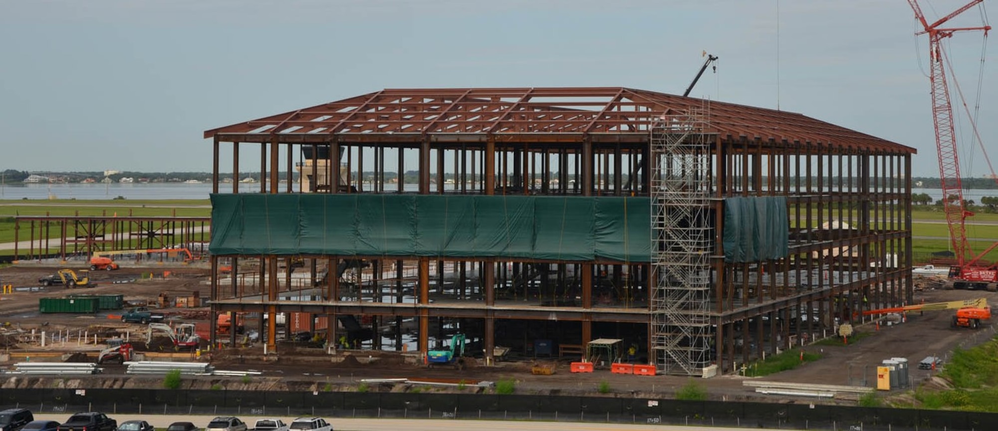 Green tarps are draped across the third level of the new Air Force Technical Applications Center that is under construction at Patrick AFB, Fla.  The tarps prevent light from emanating towards the shoreline where sea turtles make their nests.  (U.S. Air Force photo by Susan A. Romano)