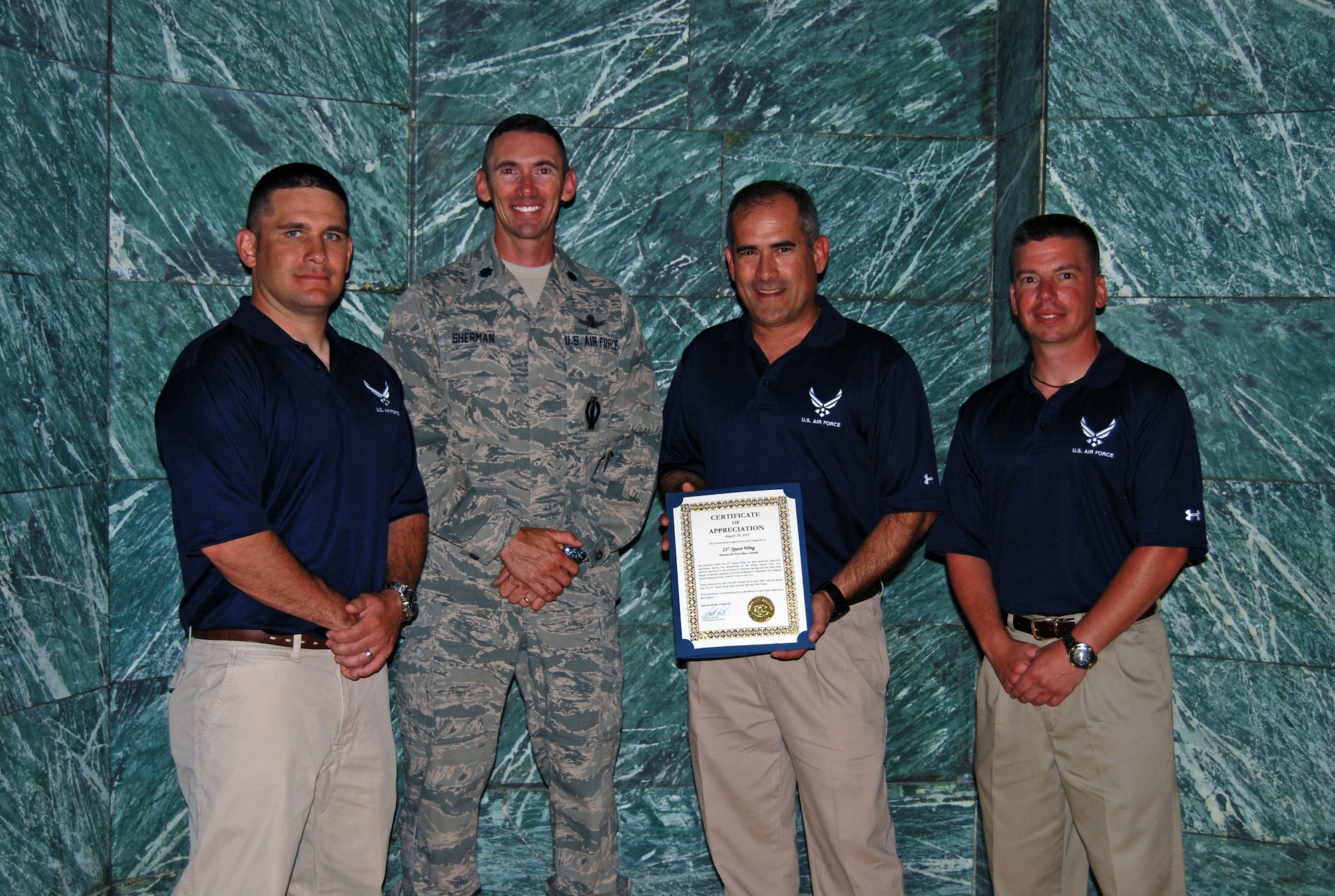 (Left to right) Capt. Ryan Durand, 16th Space Control Squadron; Lt. Col. Roger Sherman, 16th SPCS commander; and Master Sgts. Andres Martinezarchilla and Jason Lange, 16th SPCS; accept a certificate of recognition on behalf of the 21st Space Wing for their volunteer efforts related to the Waldo Canyon fire recovery at a city council meeting Aug. 28. Volunteers from more than two dozen area military organizations volunteered more than 1,300 hours as part of the recovery, helping with trash removal, traffic control, working with Army Corps of Engineers in making a sand bagging video for future natural disasters, and debris removal from destroyed homes. The fire broke out June 23 west of Manitou Springs, and over the course of several days spread north and east, burning into Colorado Springs, destroying 346 homes. At the peak of the fire, more than 35,000 residents, including many military families, were evacuated from their homes. (U.S. Air Force photo/Lea Johnson)
