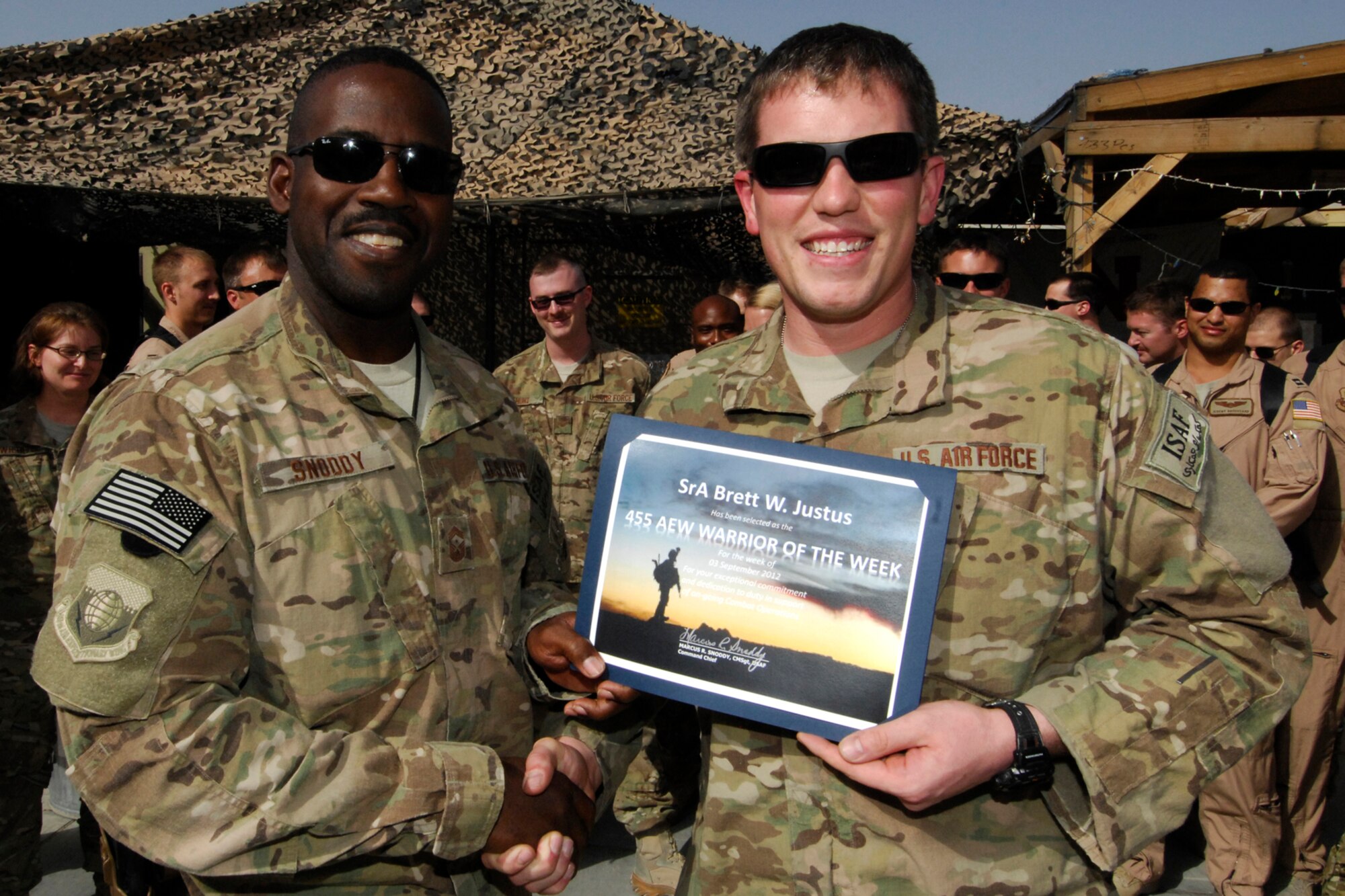 CMSgt Marcus Snoddy, 455th Air Expeditionary Wing command chief, presents the Warrior of the Week award to SrA Brett Justus, 4th Expeditionary Reconnaissance Squadron intel analyst, at Bagram Airfield, Afghanistan, Sept. 4, 2012. Justus produces daily intelligence products such as pre-mission briefs, mission reports, tracker sheets, feedback as well as providing current intelligence updates to aircrew prior to and after missions. He also helps aircrew become acclimated to the Squadron and the missions by providing a current threat brief. (U.S. Air Force photo/SSgt Jeff Nevison)