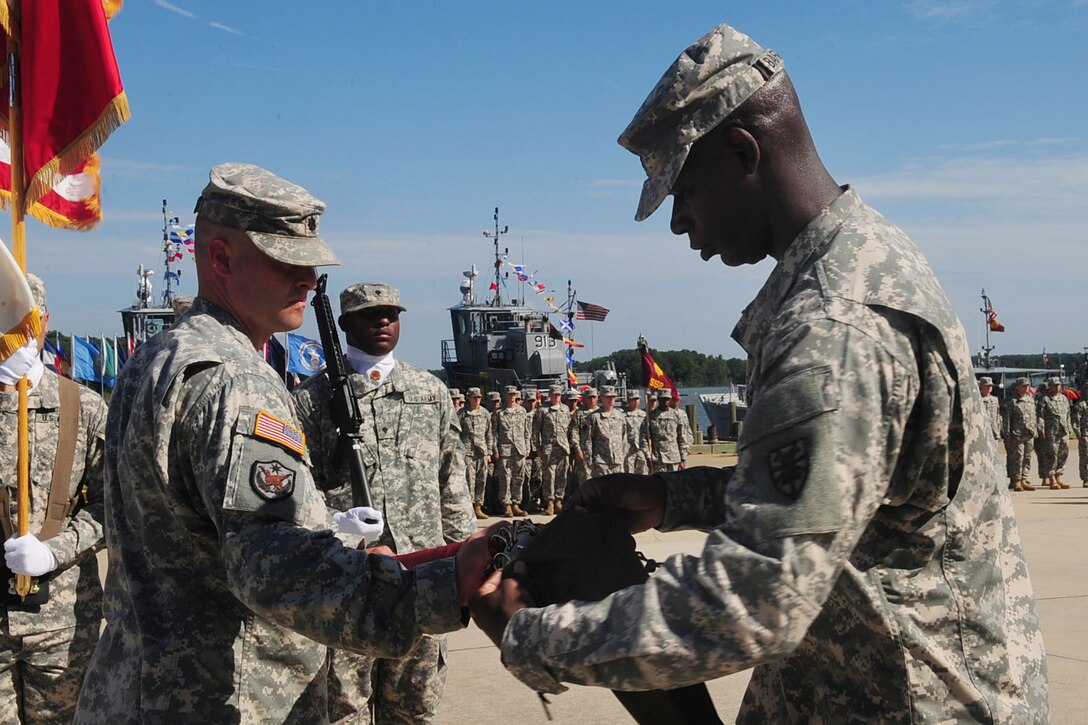 U.S. Army Lt. Col. Curt L. Stewart, 6th Transportation Battalion, 7th Sustainment Brigade commander, left, assists Command Sgt. Maj. Anthony Bargaineer of the 6th Trans. Bn. as he furls the colors during an inactivation ceremony at Fort Eustis, Va. Aug. 28, 2012. The unit first activated at Fort Eustis 60 years ago, standing up Aug. 15, 1952 and serving in World War II, Vietnam, and Operations Restore Hope and New Dawn. (U.S. Air Force photo by Staff Sgt. Ashley Hawkins/Released)