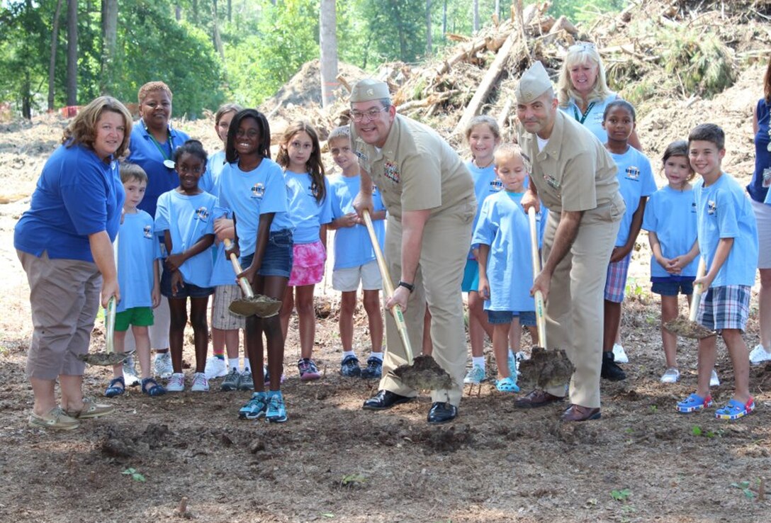 Along with the help of children from the Morale, Welfare and Recreation Youth Center, Captain Lowell Crow, Naval Weapons Station Yorktown commanding officer, broke ground on the new $3.8 million MWR Youth Center for the installation. The new center, which will take roughly nine months to complete, will have an increased capacity for 90 kids (up from the current 30) and will lessen the environmental impact on the installation by lowering water and electricity consumption. Breaking ground with the gold shovels are, from left to right, Youth Center Director Tina Mullins, Naomi McLean, Captain Lowell Crow, CMDCM(AW/SW) Dominick Torchia, Navy Region Mid-Atlantic Command Master Chief, and Cameron Wells. (Courtesy photo by Mark Piggott / Released)