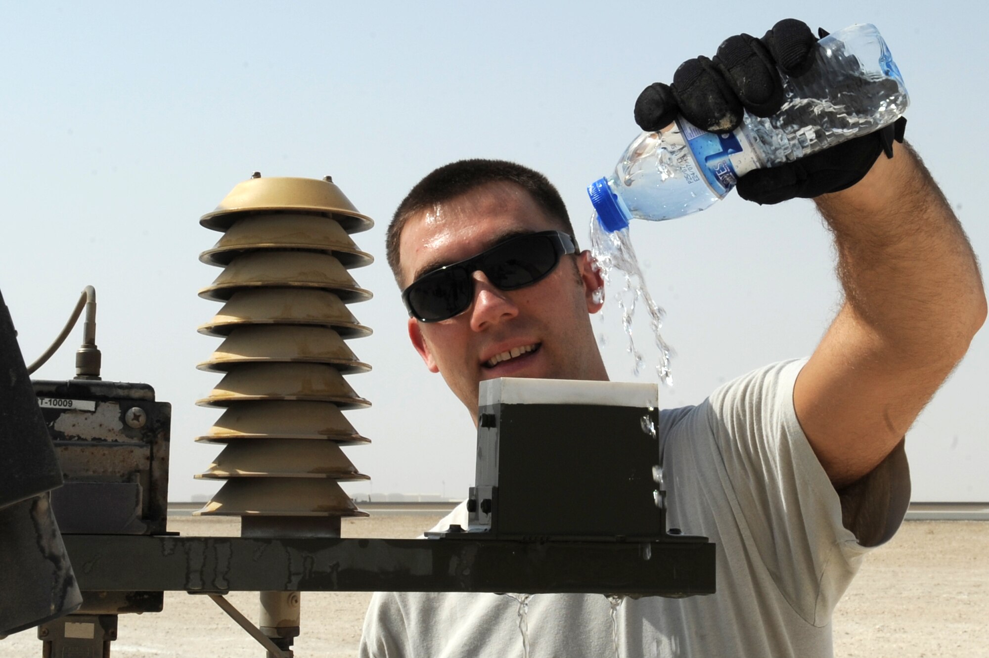 SOUTHWEST ASIA - U.S. Air Force Staff Sgt. Christopher Bieber, 380th Expeditionary Operations Support Squadron weather flight technician, pours water on a TMQ-53 tactical weather observation station during a periodic maintenance inspection Aug. 31, 2012. Bieber, a Spokane, Wash., native, is deployed to the 380th Air Expeditionary Wing from Fairchild Air Force Base, Wash. (U.S. Air Force photo/Master Sgt. Scott MacKay)