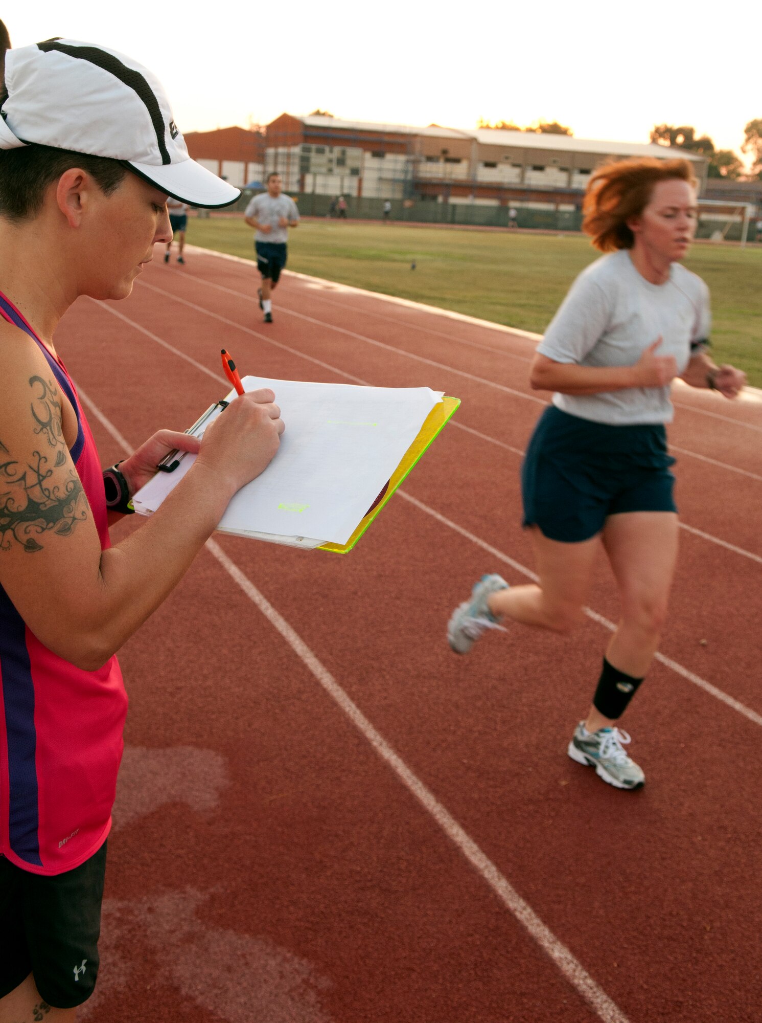 Bobbi Cervantez, 39th Medical Group Health and Wellness Center exercise physiologist, records students running in her class at the base track Aug.28, 2012, Incirlik Air Base, Turkey. The class is designed to help those who have scored lower than 45 on the cardiovascular portion of their fitness assessment test improve their run time. (U.S. Air Force photo by Senior Airman Daniel Phelps/ Released))