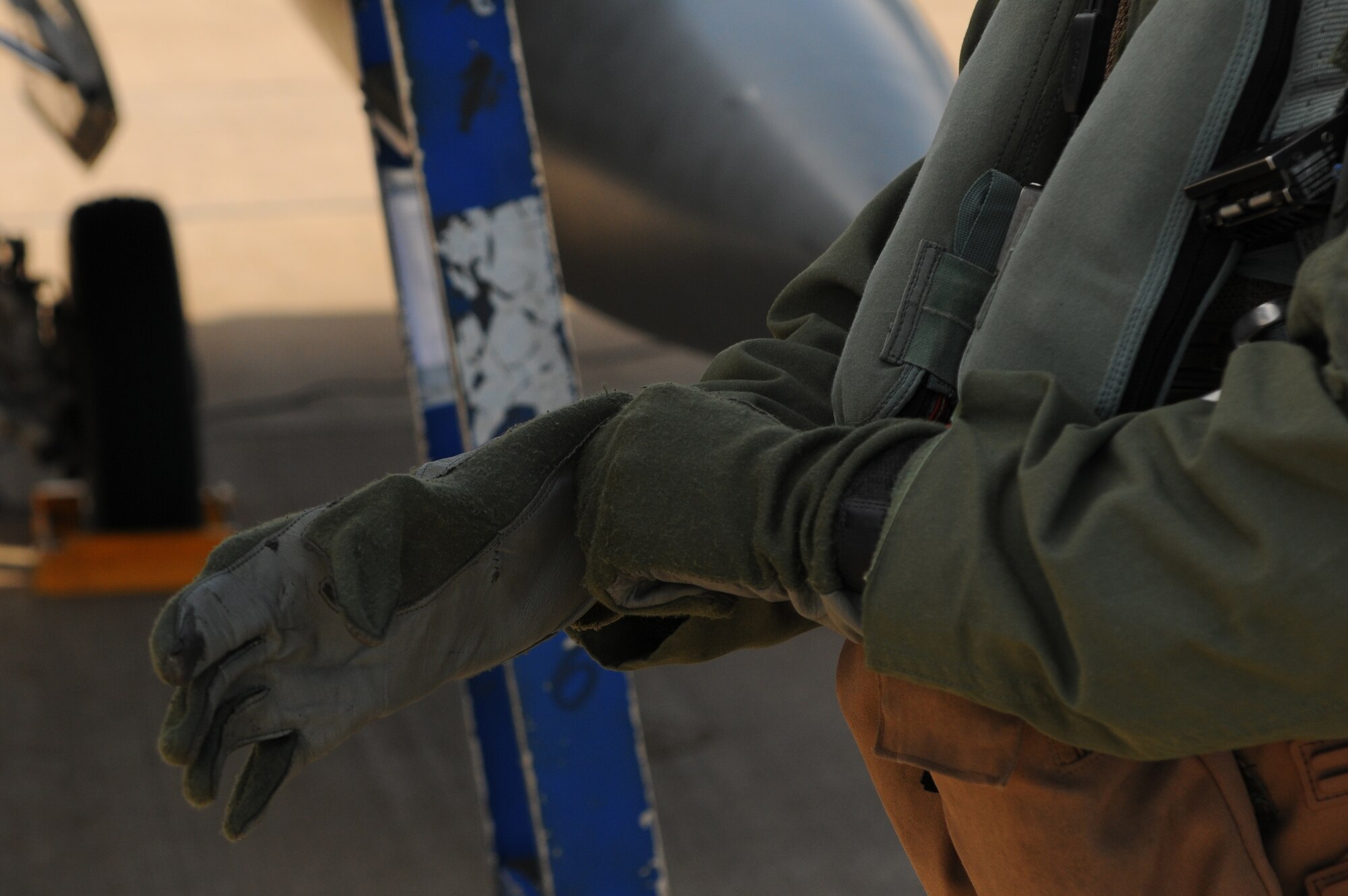 KALLAX AIR BASE, Sweden -- Maj. Brian Scott, 480th Fighter Squadron pilot, puts on a pair of non-flammable flight gloves before boarding his assigned F-16 Fighting Falcon aircraft here Sept. 3 at the Nordic Air Meet 2012. The multinational training exercise brought together more than 50 aircraft from the United States, Great Britain, Denmark, Finland, Switzerland and Sweden to participate in tactical role-playing training missions. The three week exercise enabled the different nations to exchange aerial tactics and capabilities to improve combat power effectiveness in solo and joint environments while building and strengthening international partnerships. (U.S. Air Force Photo by Airman 1st Class Dillon Davis/Released)