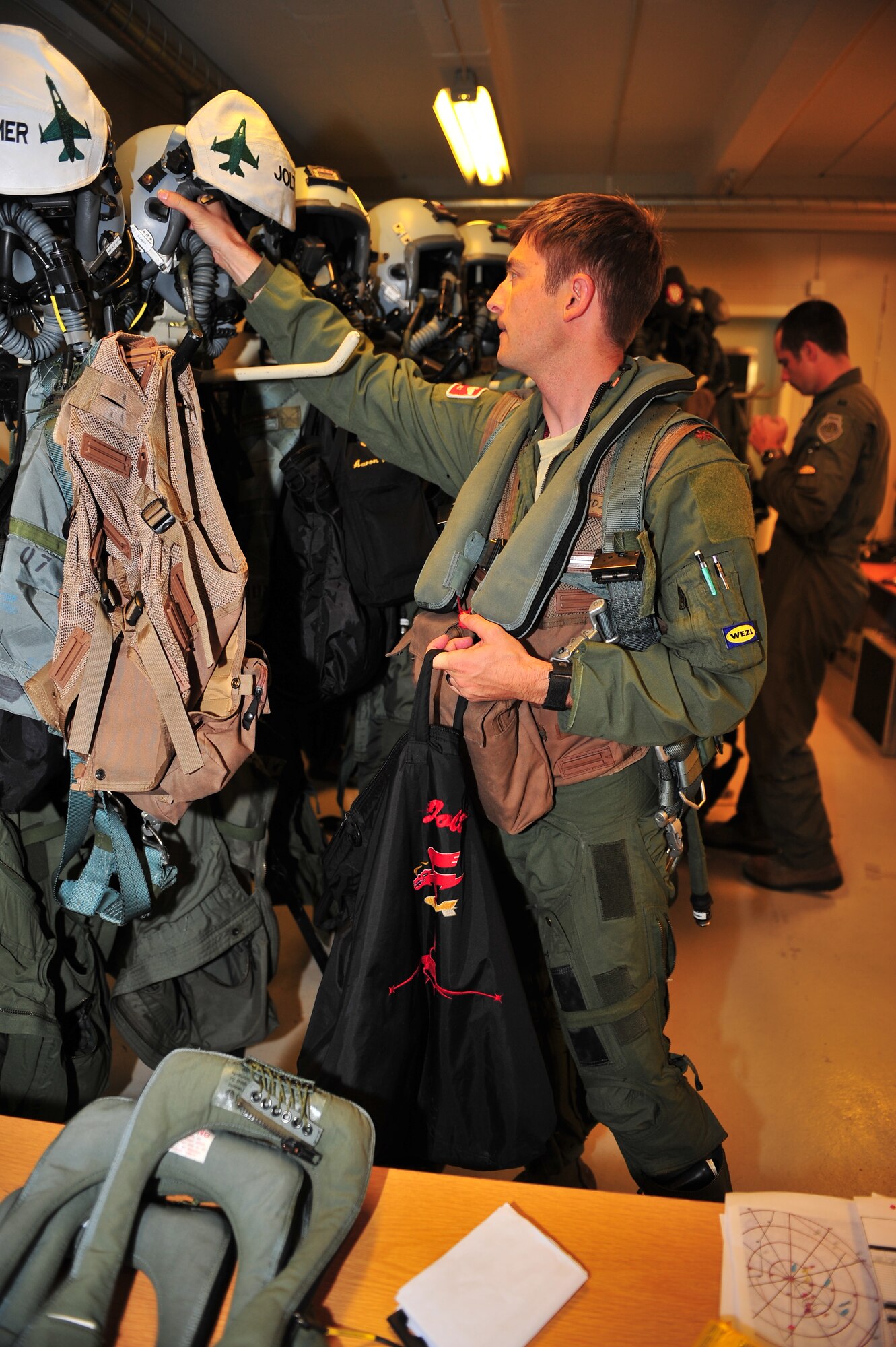 KALLAX AIR BASE, Sweden -- Maj. Brian Scott, 480th Fighter Squadron pilot, grabs his flight helmet from a shelf Sept. 3 before a flight at the Nordic Air Meet 2012. The multinational training exercise brought together more than 50 aircraft from the U.S., Great Britain, Denmark, Finland, Switzerland and Sweden air forces to participate in tactical role-playing training missions. The three week exercise enabled the different nations to exchange aerial tactics and capabilities to improve combat power effectiveness in solo and joint environments while building and strengthening international partnerships. (U.S. Air Force Photo by Airman 1st Class Dillon Davis/Released)