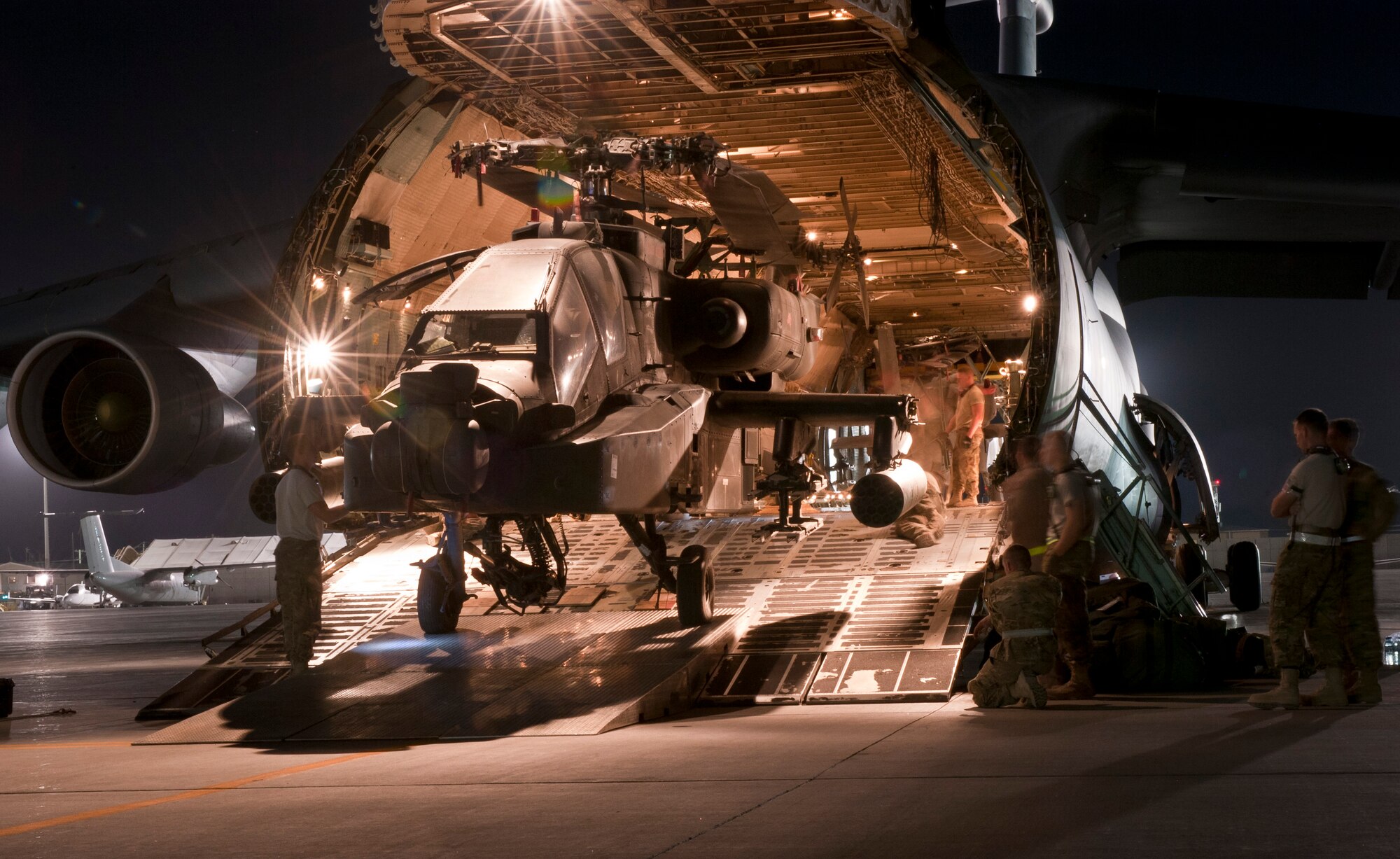 Airmen and Soldiers load a U.S. Army AH-64 Apache attack helicopter aboard a U.S. Air Force C-5B Galaxy at Bagram Airfield, Afghanistan Aug. 31, 2012. The C-5 can carry up to six Apache helicopters in a single load depending on configuration. The C-5’s payload capacity made it the ideal choice for the Relief in Place/Transfer of Authority process of the departing 82nd Combat Aviation Brigade and arriving 101st Combat Aviation Brigade. (U.S. Air Force Photo/Capt. Raymond Geoffroy)