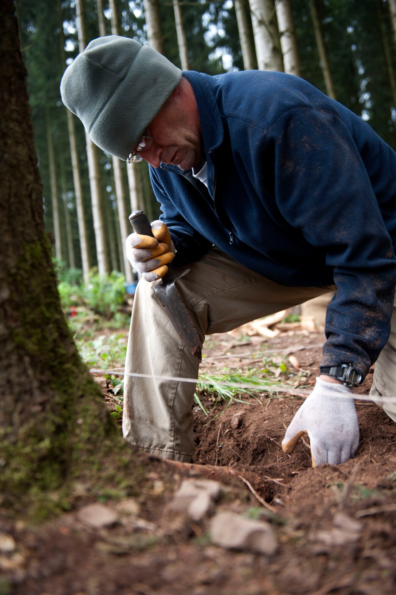 ST. VITH, Belgium – U.S. Army Sgt. Jason Tinker, Joint Prisoners of War/Missing in Action Accounting Command recovery non-commissioned officer, searches for buried articles left by a World War II aircraft crash here Aug. 29.  The Joint POW/MIA Accounting Command conducts global search and recovery operations to locate and identify unaccounted-for Americans from past conflicts and return them home with honor to support the Department of Defense’s personnel accounting efforts. (U.S. Air Force photo by Airman 1st Class Gustavo Castillo/Released)