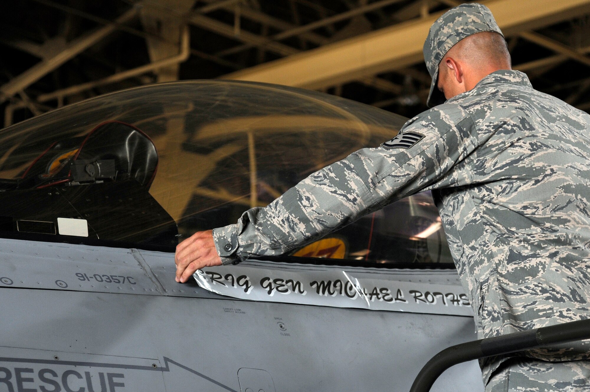 U.S. Air Force Staff Sgt. Donald Slayton, 35th Aircraft Maintenance Squadron crew chief, removes Brig. Gen. Michael Rothstein's name to unveil Col. Stephen Williams' name below the canopy of the wing's flagship F-16 Fighting Falcon during an official change of command ceremony, at Misawa Air Base, Japan, Sept. 4, 2012. The new installation and wing commander, Col. Stephen Williams, is a command pilot with more than 2,800 flying hours, including more than 260 combat hours. (U.S. Air Force photo by Tech. Sgt. Marie Brown)
