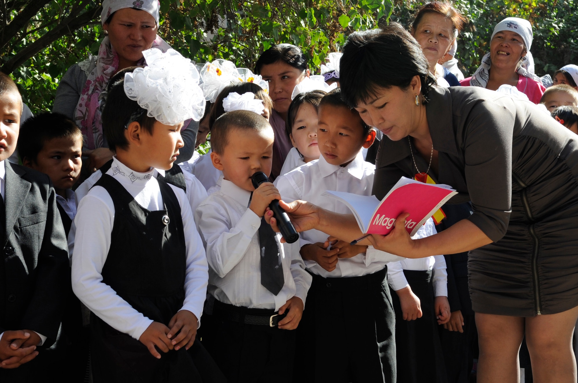 First-year students from Niznechuiskiy School 1 recite versus from a poem during the "First Bell" ceremony, Niznechuiskiy Village, Kyrgyzstan, Sept. 1, 2012.  Airmen from the Transit Center at Manas were in attendance for the ceremony and also to deliver new sports equipment and uniforms for the new school year. (U.S. Air Force photo/Master Sgt. Jason Vaught) 