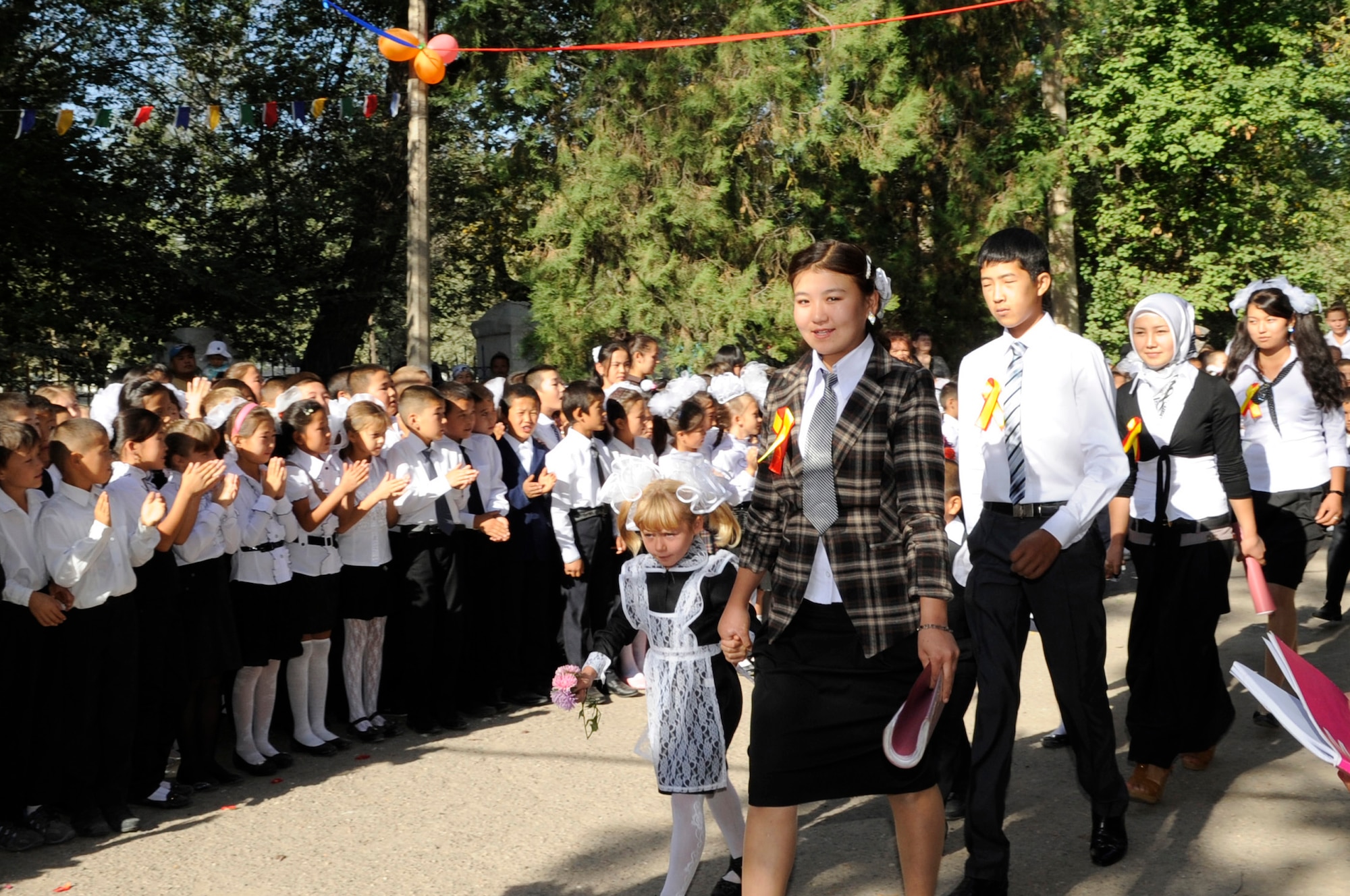Seniors in their last year of school escort first-year students to class during the "First Bell" ceremony, Niznechuiskiy Village, Kyrgyzstan, Sept. 1, 2012.  First Bell is a Russian tradition that takes place each year on Sept. 1st to signal the first day of school. First Bell marks a rite of passage where seniors, in their last year of studies, escort first-year students in a ceremony symbolizing the start of a new school year. (U.S. Air Force photo/Master Sgt. Jason Vaught)