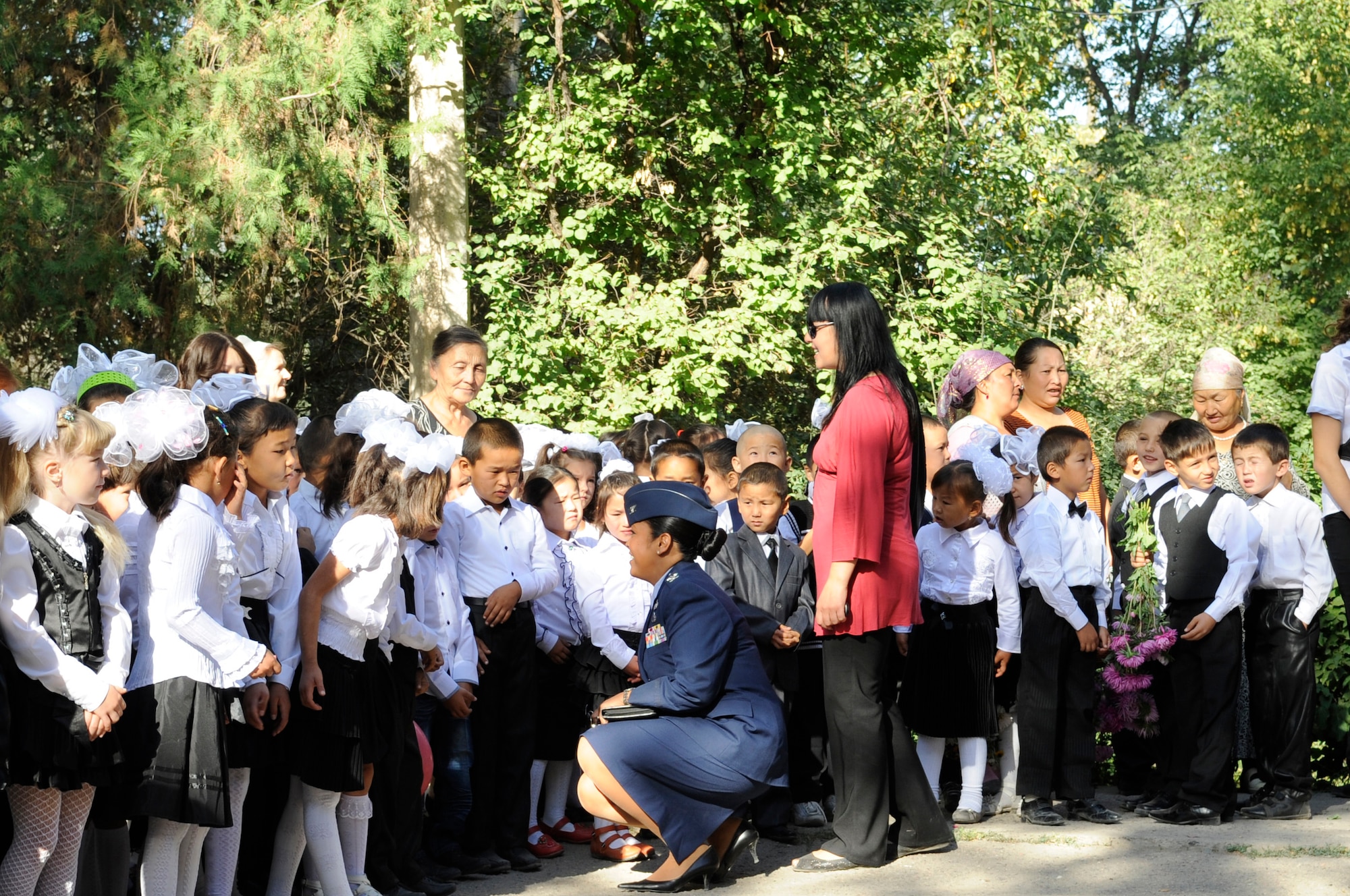 Col. Shirlene Ostrov meets with students from Niznechuiskiy School 1 to help celebrate the "First Bell" ceremony, Niznechuiskiy Village, Kyrgyzstan, Sept. 1, 2012.  Ostrov, 376th Expeditionary Mission Support Group commander and a native of Honolulu was in attendance as a guest speaker for the ceremony. First Bell is a Russian tradition and takes place each year on Sept. 1 to signal the first day of school. (U.S. Air Force photo/Master Sgt. Jason Vaught)