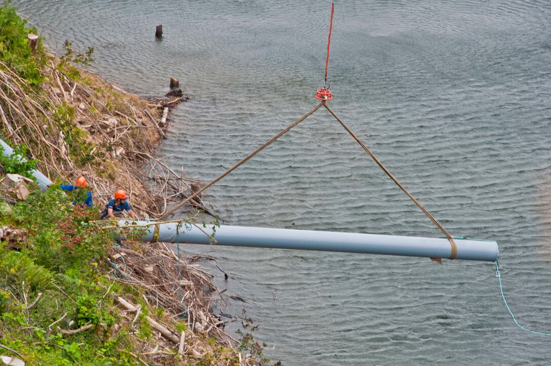 Contractors use a helicopter to transport large log booms to the Eagle Gorge Reservoir at Howard Hanson Dam.  Once transported, workers secure them safely in place.  The new booms replace older ones with shorter anchors, making the dam even safer than before, in the event of a catastrophic flood.  Repairs and upgrades have been ongoing since 2009.  Final dam safety repairs were complete with the installation of these log booms.