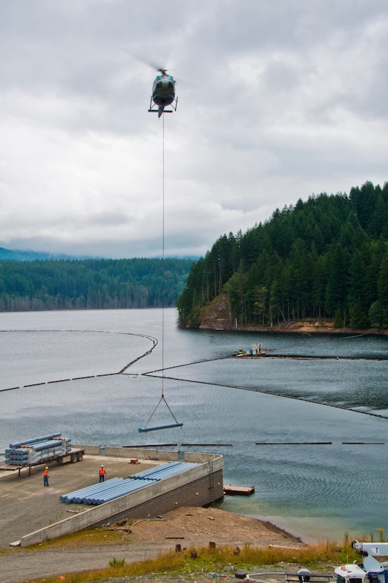 Contractors use a helicopter to transport large log booms to the Eagle Gorge Reservoir at Howard Hanson Dam.  Once transported, workers secure them safely in place.  The new booms replace older ones with shorter anchors, making the dam even safer than before, in the event of a catastrophic flood.  Repairs and upgrades have been ongoing since 2009.  Final dam safety repairs were complete with the installation of these log booms.