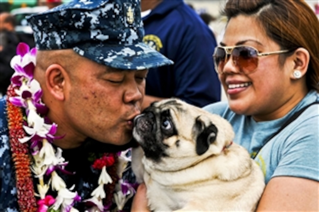 Navy Chief Petty Officer Kevin Sun reunites with his dog and other loved ones after completing Pacific Partnership 2012 as a crewmember of the USNS Mercy in Pearl Harbor, Hawaii, Sept. 2, 2012. The Mercy stopped in Pearl Harbor to drop off several crewmembers while on its way back to its homeport of San Diego.