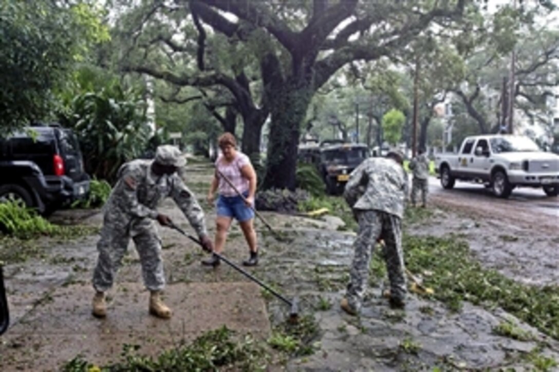 Soldiers help residents clear debris from the sidewalks of St. Charles Avenue in downtown New Orleans, during Tropical Storm Isaac, Aug. 30, 2012. The soldiers are assigned to the 1023rd Engineer Company, 528th Engineer Battalion, Louisiana National Guard.