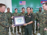 Senior Enlisted Leader HMC Chris Guckeyson presents Brig. Gen. Keo Davuth with a commemorative photo at Phnom Penh, Cambodia Aug. 24. The photo was presented on behalf of 3rd Medical Battalion, Combat Logistics Regiment 35, 3rd Marine Logistics Group at the conclusion of Cambodia  Medical Exercise 12.2.