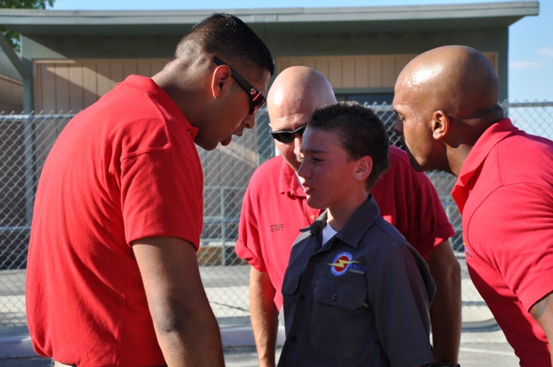 Cpl. Jorge Cazares and Lance Cpl. Luis E. Castro, legal and adjutant clerks with Headquarters Battalion, Marine Corps Logistics Base Barstow, Calif. try to motivate and instill discipline into a SHOCK student. The SHOCK program is designed to teach High Desert teens leadership, discipline and moral courage. Photo by: Pfc. Norman Eckles