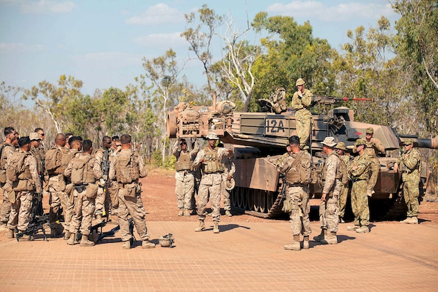 Marines gather around an Australian M1A1 tank for a debrief with Australian soldiers after executing a bilateral assault at the urban operations training facility at Mount Bundy Training Area Sept. 5.
