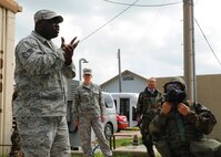 Staff Sgt. Emmanuel Oloyede, 8th Civil Engineer Squadron, and a Korean civilian, demonstrate how to properly wear the M50 gas mask during a training session on Kunsan Air Base, Republic of Korea, Sept. 5. Oloyede also covered topics such as alarm signals, mission-oriented protective posture and post-attack actions. (U.S. Air Force Photo/Staff Sgt. Jonathan Fowler)