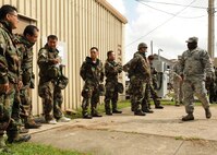 Staff Sgt. Emmanuel Oloyede, 8th Civil Engineers Squadron, instructs Korean civilians on proper wear of chemical protective equipment on Kunsan Air Base, Republic of Korea, Sept. 5, 2012. Oloyede also covered topics such as alarm signals, mission-oriented protective postures and post-attack actions. (U.S. Air Force Photo/Staff Sgt. Jonathan Fowler)