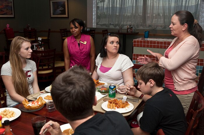 Stephanie Garnes, 99th Force Support Squadron Airman and Family Readiness Center key spouse program coordinator, and Sheri Marler, 99th Air Base Wing key spouse mentor, wife of Chief Master Sgt. Vincent Marler, 99th Air Base Wing command chief, speak with family members of a deployed airman at the Desert Oasis dining facility during a deployed and remote family meal Sept. 5, 2012, at Nellis Air Force Base, Nev. Aside from the deployed and remote family meal, a deployed spouses briefing is offered at the AFRC quarterly. (U.S. Air Force photo by Staff Sgt. Christopher Hubenthal) 