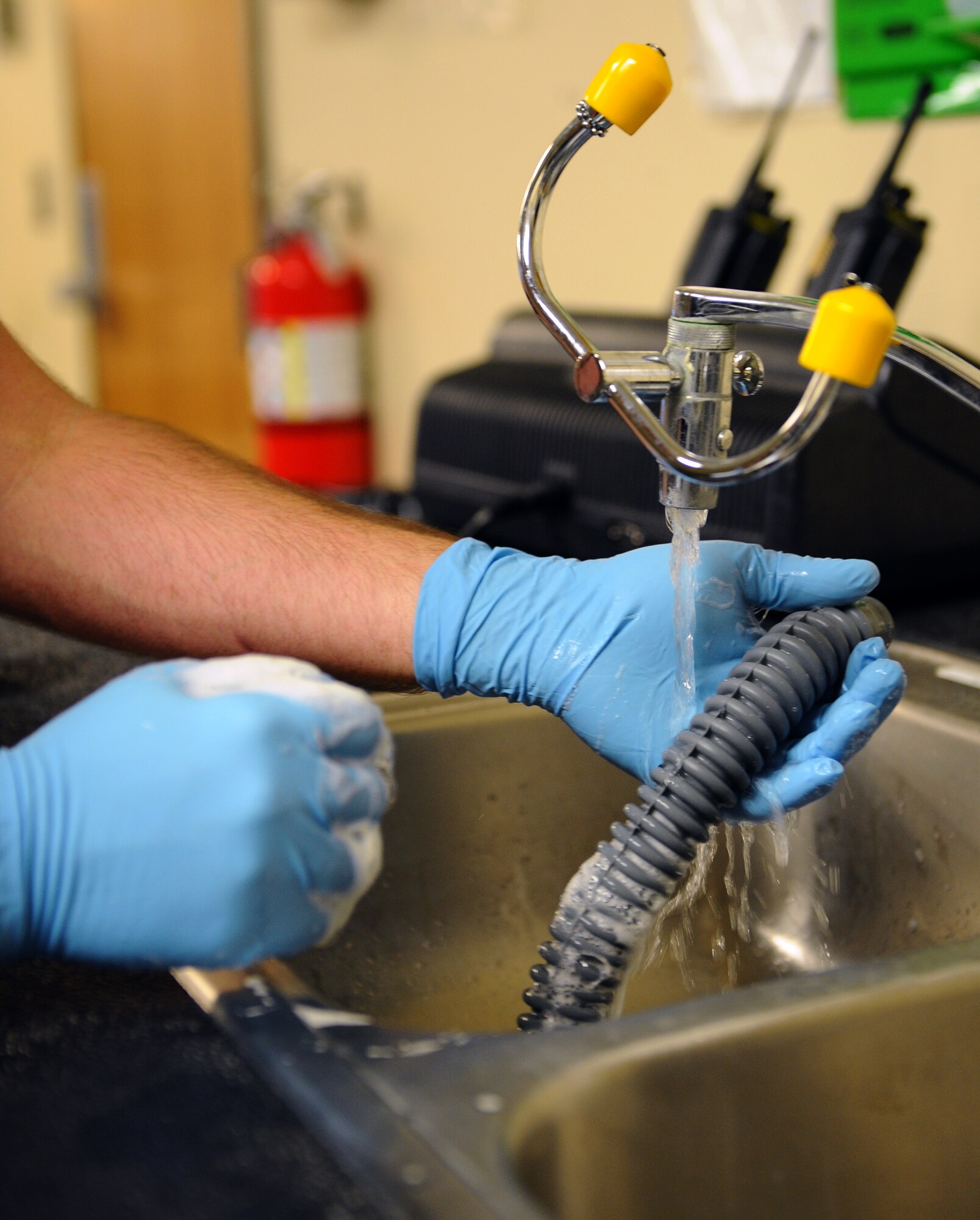 Airman 1st Class Andrew Jones, 2nd Operations Support Squadron aircrew flight equipment, cleans an oxygen hose from an aircrew helmet on Barksdale Air Force Base, La., Sept. 5. Every part of the helmet is cleaned to remove dirt and anything that may get the wearer sick. AFE Airmen use a mild detergent, gauze pads and hot water when cleaning equipment. (U.S. Air Force photo/Airman 1st Class Benjamin Gonsier)(RELEASED)