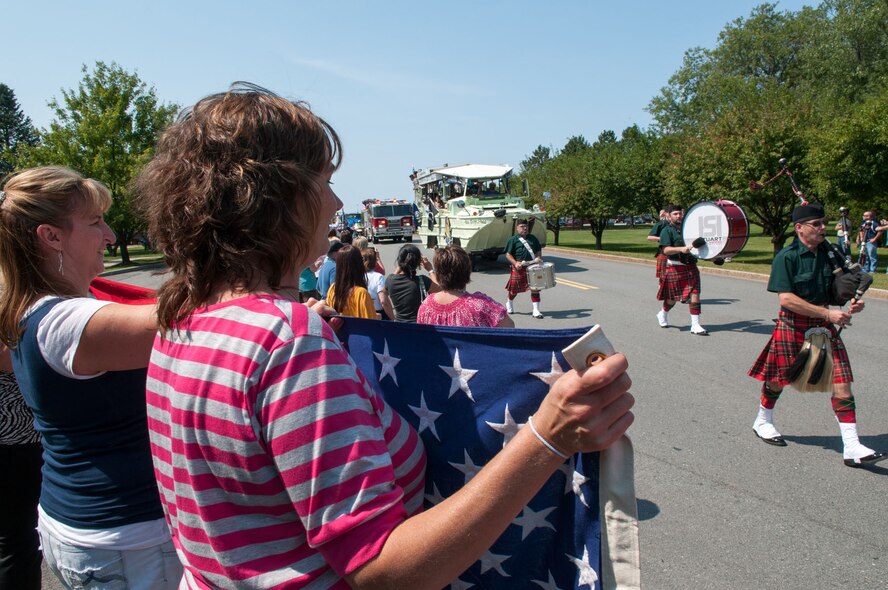 HANSCOM AIR FORCE BASE, Mass. – The Hanscom community lines the street to cheer as the parade passes before Heroes Homecoming Aug. 30. A bagpipe and drum team led the deployed servicemembers and their families to the ceremony location. (U.S. Air Force photo by Rick Berry)