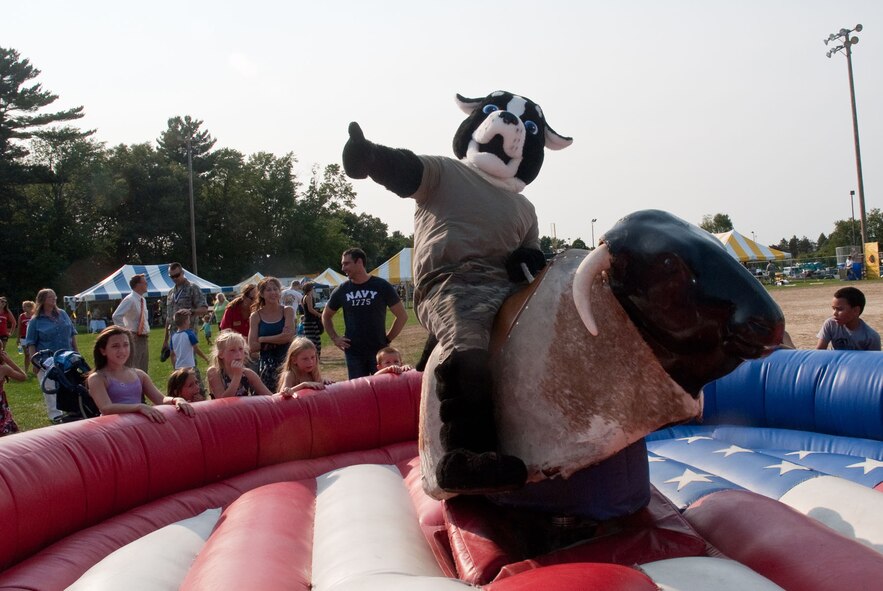HANSCOM AIR FORCE BASE, Mass. – Freddy Freedom goes for a ride on the mechanical bull at BBQ and Blues event. Attendees were also treated to musical entertainment, dunk tanks, food and more. (U.S. Air Force photo by Mark Herlihy)