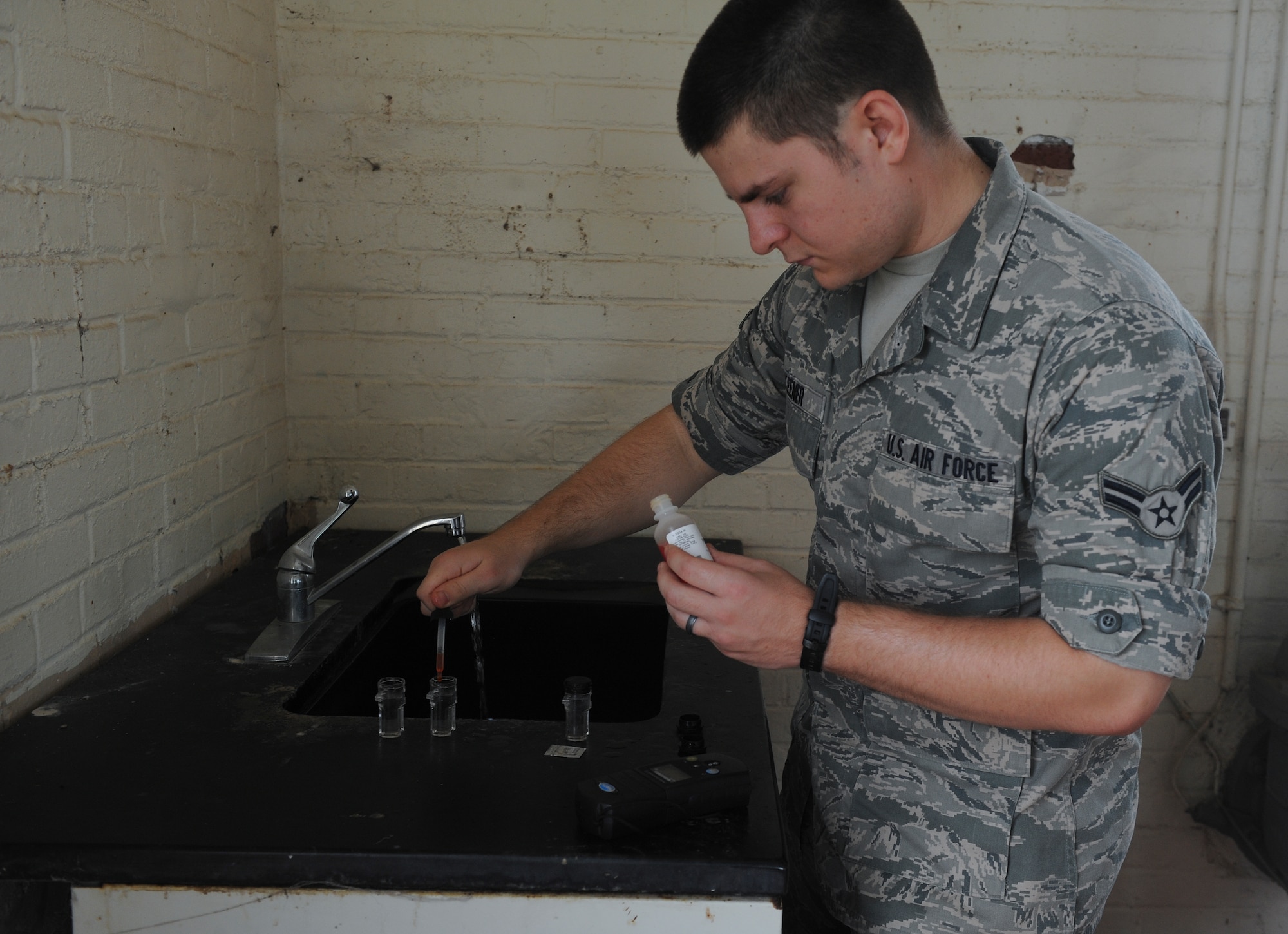 U.S. Air Force Airman 1st Class Andrew Keener, 23d Aerospace Medicine Squadron bioenvironmental engineer, drops phenol red into a water sample at Moody Air Force Base, Ga., Aug. 30, 2012. Phenol red is a red dye used as a pH indicator to show acidity of a water sample. (U.S. Air Force photo by Airman 1st Class Olivia Dominique/Released)
