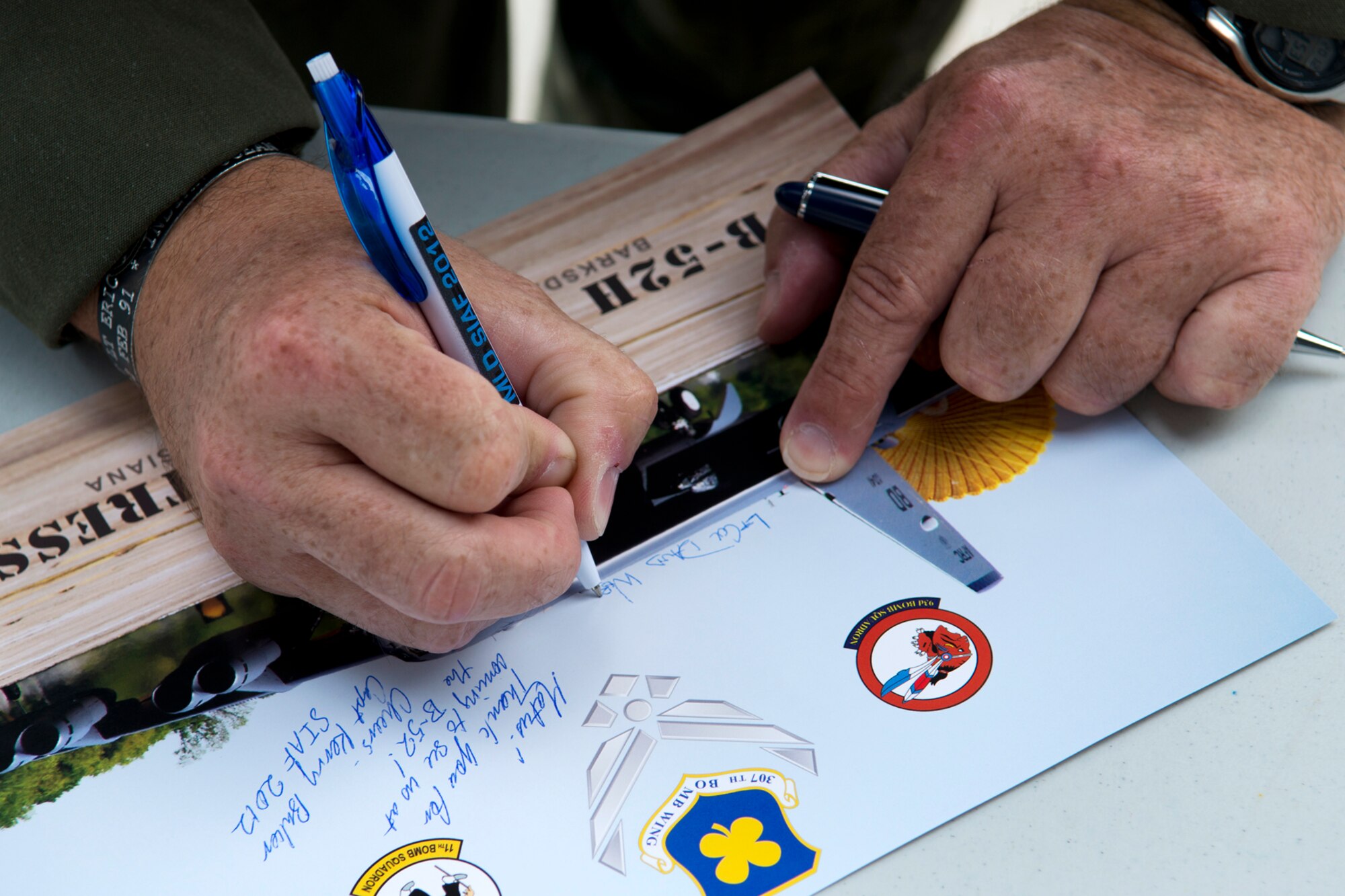 A 93rd Bomb Squadron B-52H Stratofortress aircrew member autographs a picture, Aug. 31, 2012, Sliac, Slovakia. The 93 BS, assigned to the 307th Bomb Wing, Barksdale Air Force Base, La., deployed one B-52 to Sliac in support of the Slovak International Air Fest air show and gave local school kids a tour of the aircraft. (U.S. Air Force photo by Master Sgt. Greg Steele/Released)