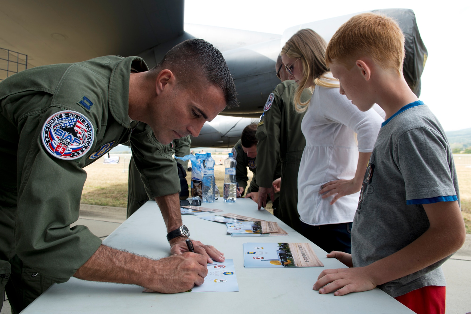 U.S. Air Force Capt. Kerry Baker, a 93rd Bomb Squadron radar navigator, signs a B-52H Stratofortress fact sheet for a Slovak school student on Aug. 31, 2012, Sliac, Slovakia. Local students were given a special tour of the B-52 a day prior to the start of the Slovak International Air Fest air show. (U.S. Air Force photo by Master Sgt. Greg Steele/Released)