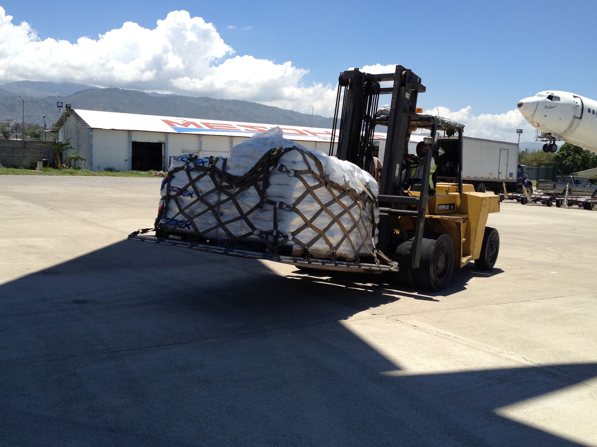 WRIGHT-PATTERSON AIR FORCE BASE, Ohio – A forklift moves pallets of rice and other much needed supplies in Haiti that were unloaded from a 445th Airlift Wing C-17 Globemaster III Aug. 31. The C-17 moved more than 105,000 pounds of cargo to and from Joint Base Charleston, S.C., to Haiti as part of the Denton Program, a program that allows donors to use space available on U.S. military cargo planes to transport humanitarian goods and equipment to countries in need. (Courtesy photo)