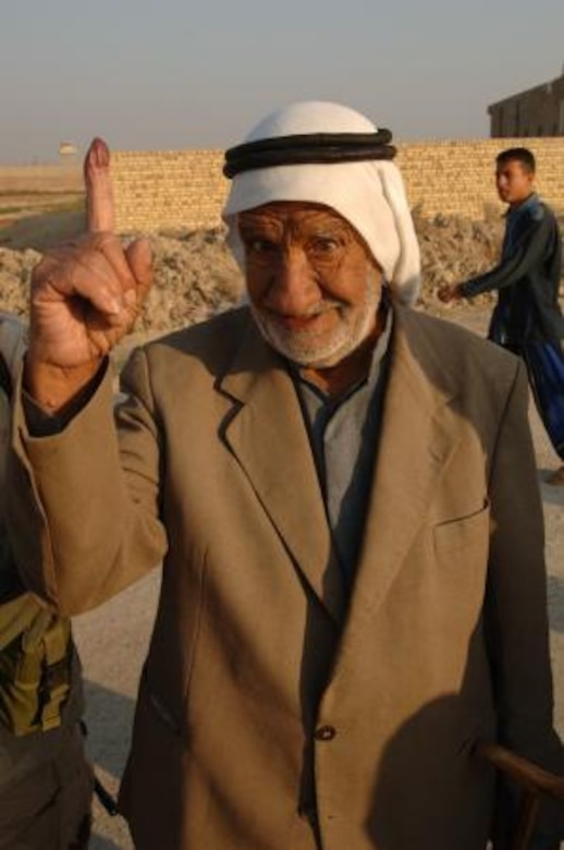 An Iraqi man proudly displays his ink stained finger after voting. (U.S. Army photo/Pfc. William Servinski II)