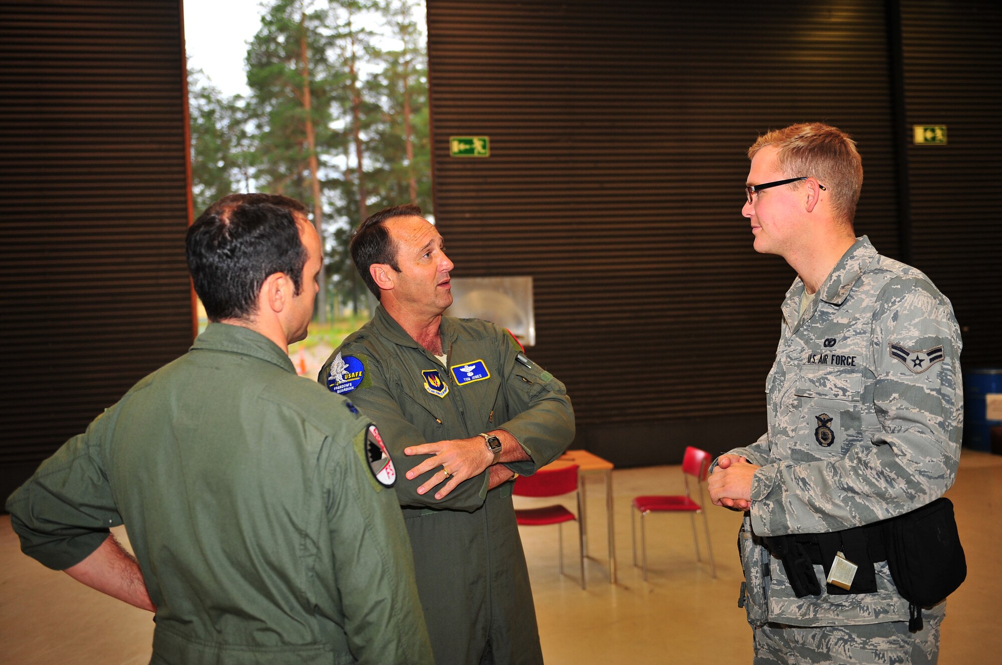 KALLAX AIR BASE, Sweden -- Lt. Gen. Tom Jones, left, U.S. Air Forces in Europe vice commander, talks to Airman 1st Class Andrew Trautmann, 52nd Security Forces Squadon patrolman, here Sept. 4 about Trautmann's experience during his incentive flight in an F-16 Fighting Falcon during the Nordic Air Meet 2012. The multinational training exercise brought together more than 50 aircraft from the United States, United Kingdom, Denmark, Finland, Switzerland and Sweden to participate in tactical role-playing training missions. The three week exercise enabled the different nations to exchange aerial tactics and capabilities to improve combat power effectiveness in solo and joint environments while building and strengthening international partnerships. (U.S. Air Force Photo by Airman 1st Class Dillon Davis/Released)