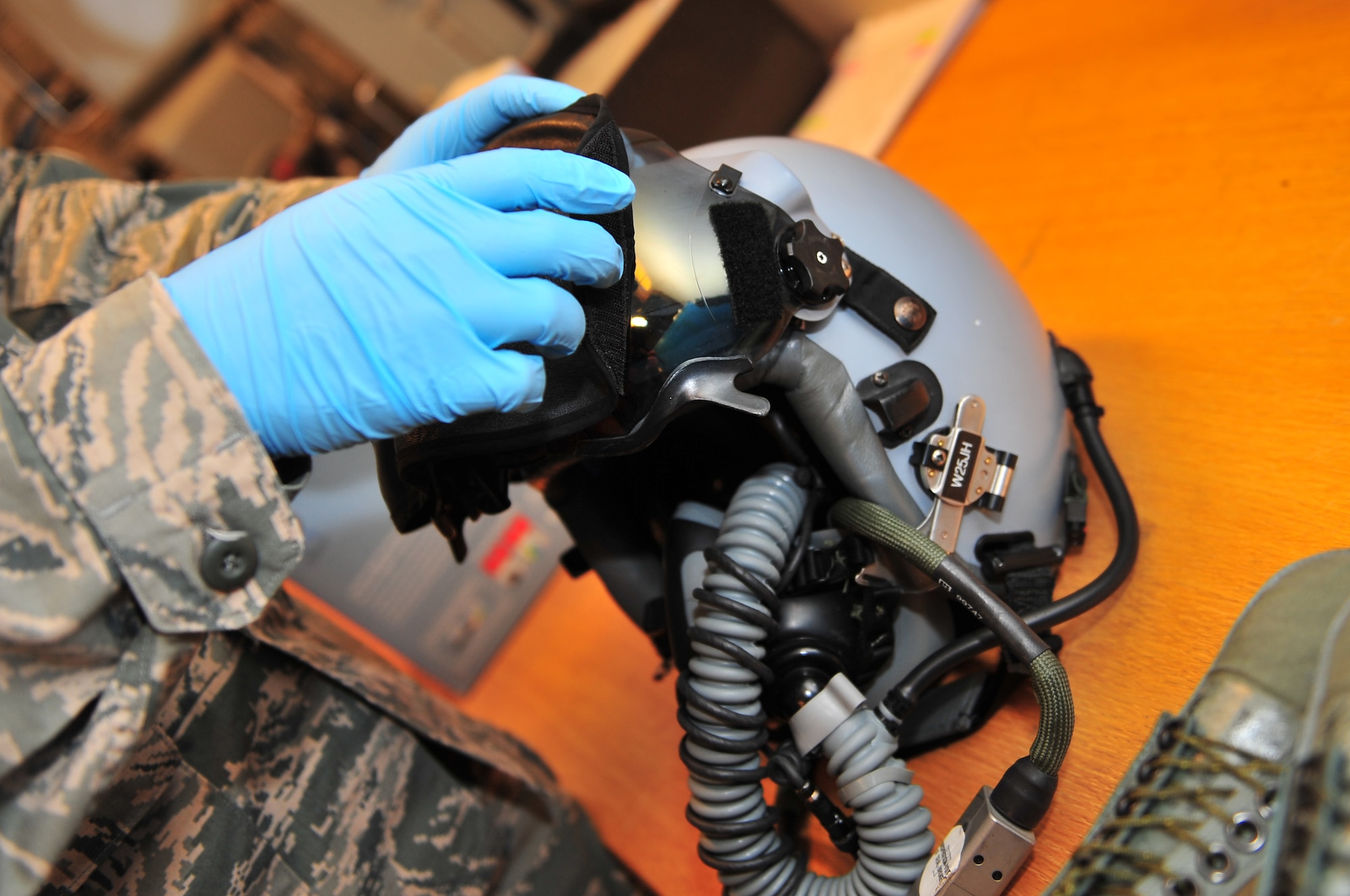 KALLAX AIR BASE, Sweden -- Airman 1st Class Niall Spradley, 52nd Operations Support Squadron, attaches a visor to a heads up display on a pilot's helmet here Sept. 4 before flight in support of the Nordic Air Meet 2012. The multinational training exercise brought together more than 50 aircraft from the U.S., Great Britain, Denmark, Finland, Switzerland and Sweden to participate in tactical role-playing training missions. The three week exercise enabled the different nations to exchange aerial tactics and capabilities to improve combat power effectiveness in solo and joint environments while building and strengthening international partnerships. (U.S. Air Force Photo by Airman 1st Class Dillon Davis/Released)