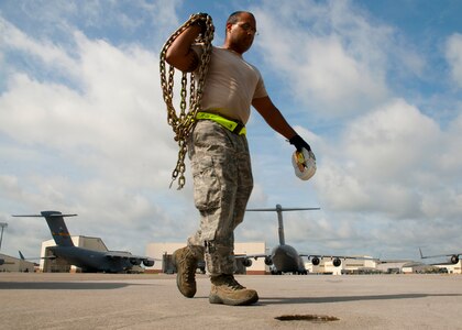 Senior Airman Derik Winston, 437th Aerial Port Squadron air transportation journeyman prepares to replace existing chains on a C-17 Globemaster III Aug. 29, 2012, at Joint Base Charleston – Air Base, S.C. The chains secure pallets on the aircraft during flight. (U.S. Air Force photo by Staff Sgt. Katie Gieratz)