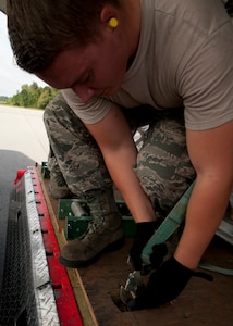 Senior Airman David May, 437th Aerial Port Squadron air transportation journeyman, ties down a pallet on an L100 aircraft Aug. 29, 2012, at Joint Base Charleston – Air Base, S.C. The pallets contained food and medical supplies to assist humanitarian efforts in Soto Cano Air Base, Honduras. (U.S. Air Force photo by Staff Sgt. Katie Gieratz)