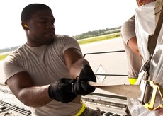 Airman 1st Class Melvin Hamilton, 437th Aerial Port Squadron  air transportation journeyman, tightens a pallet strap Aug. 29, 2012, at Joint Base Charleston – Air Base, S.C. The pallets contained food and medical supplies to assist the U.S. embassy Soto Cano, Honduras. (U.S. Air Force photo by Staff Sgt. Katie Gieratz)