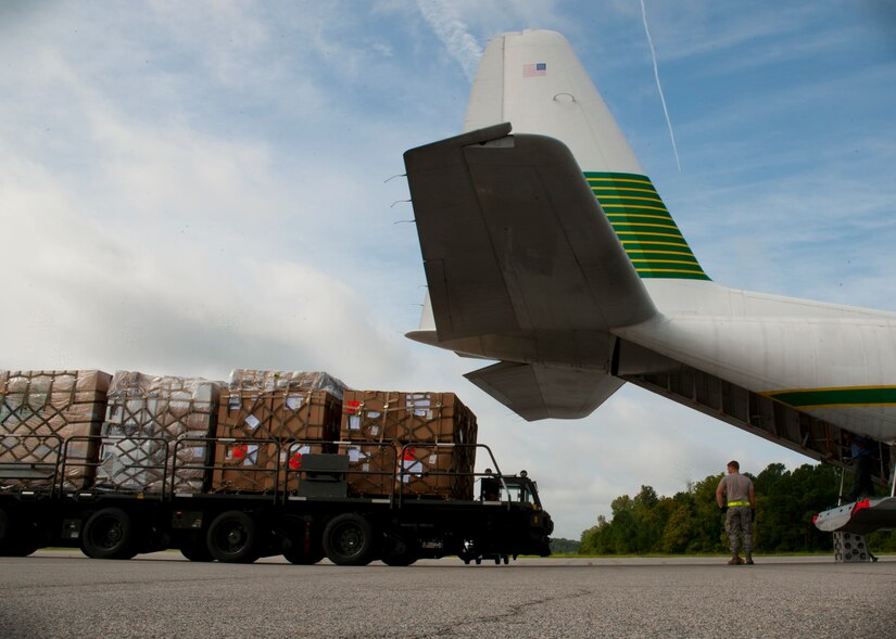 Senior Airman David May, 437th Aerial Port Squadron air transportation journeyman, guides Senior Airman Ivan Fernandez, 437th APS, journeyman as he positions the 60k tunner for unloading Aug. 29, 2012, at Joint Base Charleston – Air Base, S.C. The pallets contained food and medical supplies destined for Soto Cano Air Base, Honduras. (U.S. Air Force photo by Staff Sgt. Katie Gieratz)