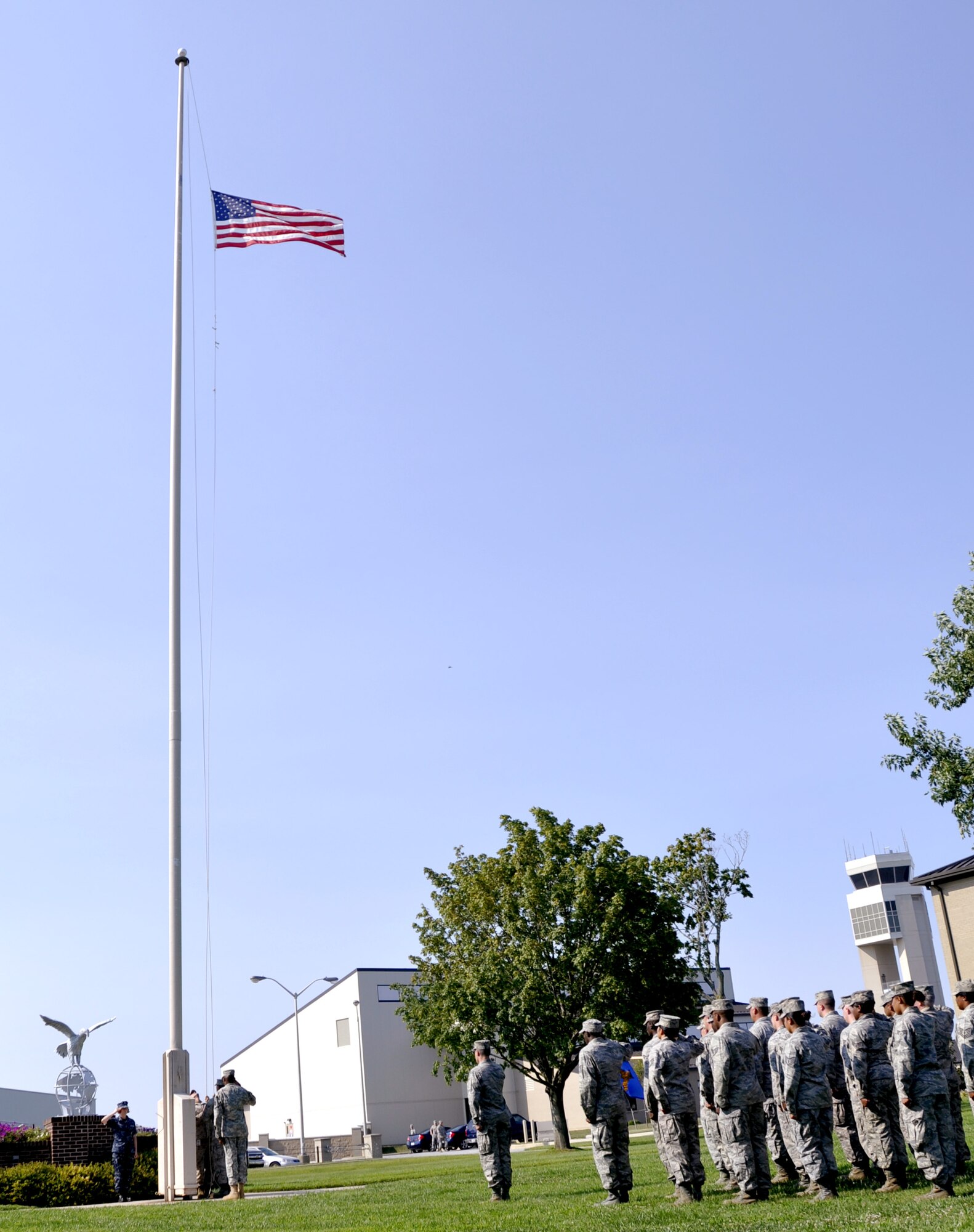 Members of Air Force Mortuary Affairs Operations salute as the flag is lowered during retreat at the base flag pole Aug. 31, 2012, at Dover Air Force Base, Del. (U.S. Air Force photo by Staff Sgt. Caitlin Jones)