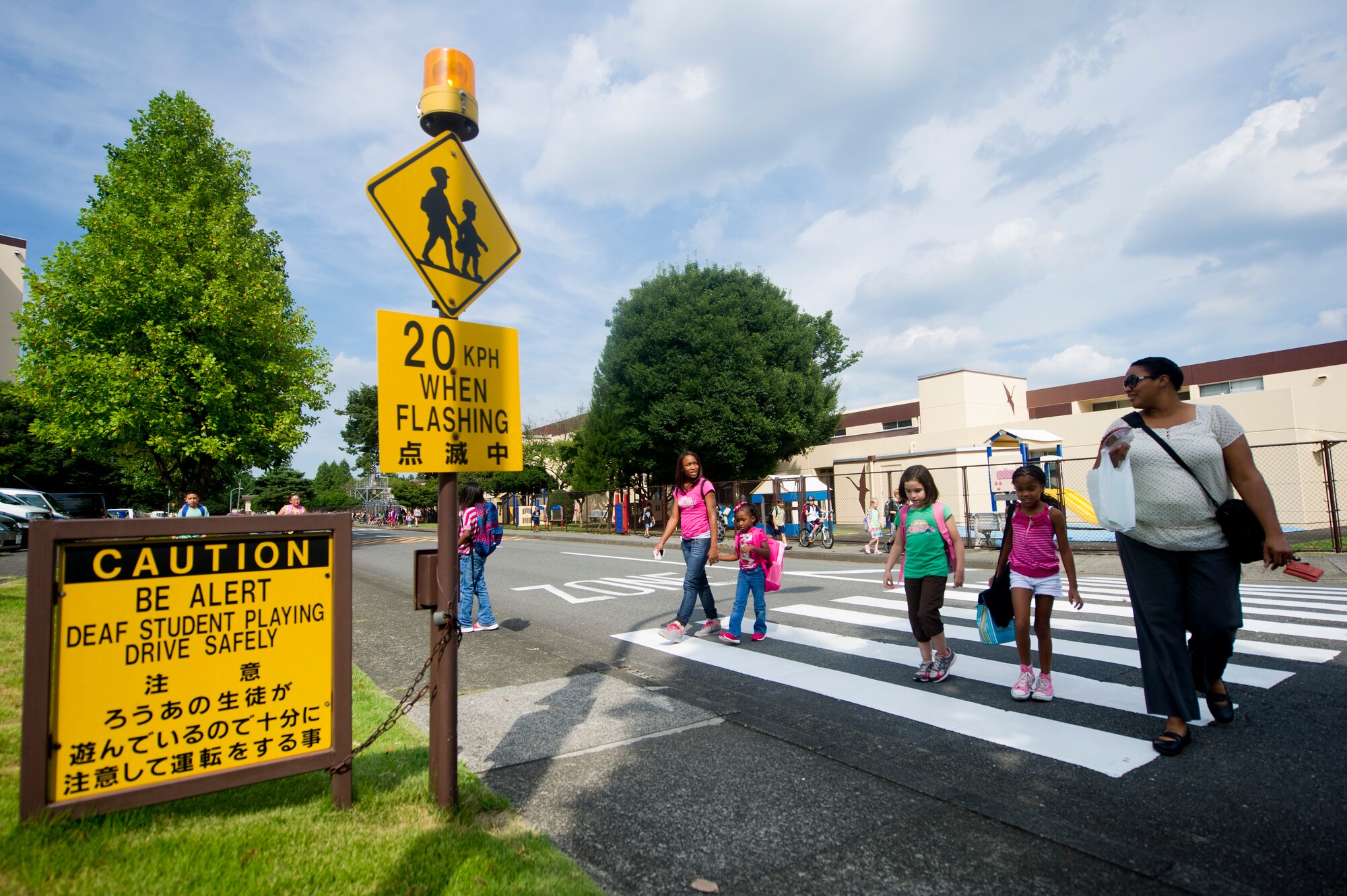YOKOTA AIR BASE, Japan -- Parents accompany their children crossing the street after school Sept. 5, 2012, at Yokota Air Base, Japan. Now that school is back in session, base residents are urged to pay extra attention, especially around school zones. (U.S. Air Force photo by Staff Sgt. Stacy Moless) 